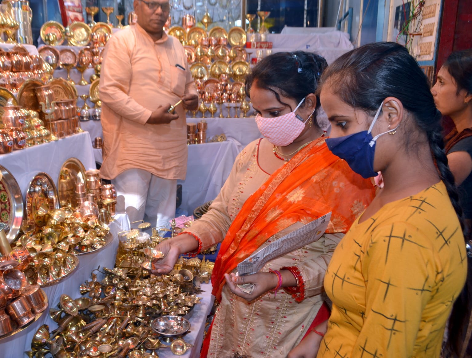 दिवाली पूजन के लिए पूजा सामग्री खरीदती महिला। संवाद दिवाली पूजन के लिए पूजा सामग्री खरीदती महिला। संवाद