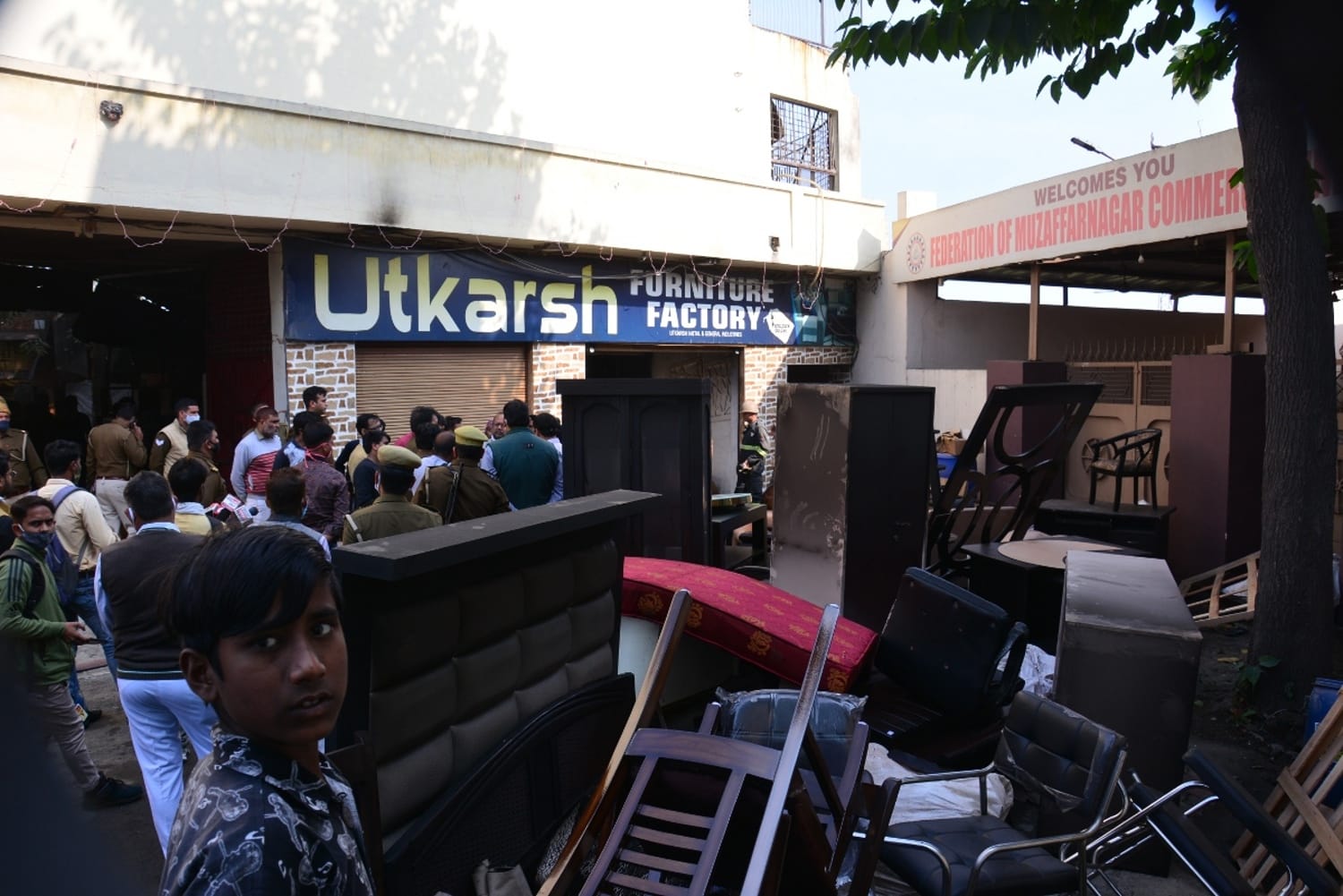 मेरठ रोड पर फर्नीचर फैक्टरी में लगी आग के बाद जमा भीड़ व पडा फर्नीचर ।