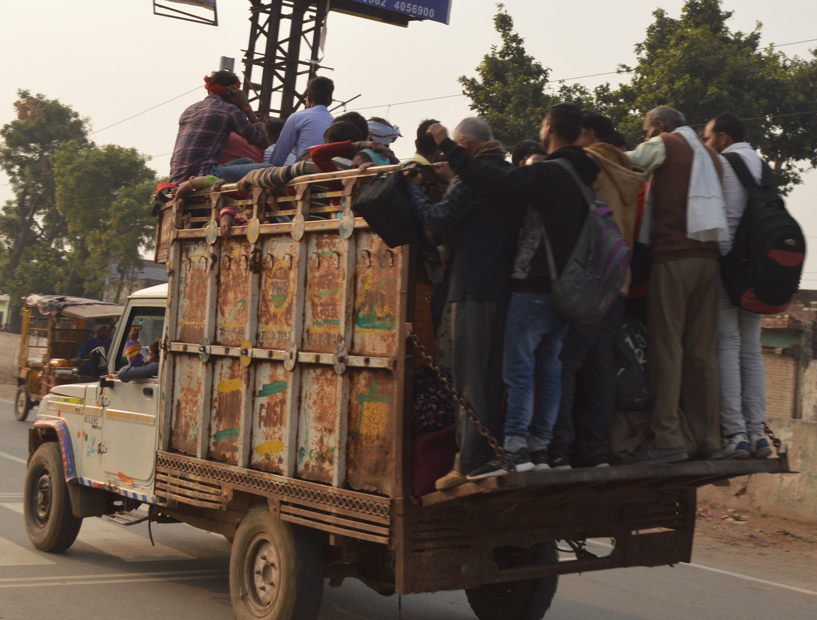 डग्गेमार वाहन पर लटक कर यात्रा करते यात्री।