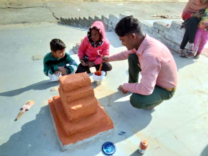 मानकमऊ स्थित बड़ी नहर के घाट पर पूजन वेदी को सजाता श्रद्धालु। साथ में बैठे उसके बच्चे। मानकमऊ स्थित बड़ी नहर के घाट पर पूजन वेदी को सजाता श्रद्धालु। साथ में बैठे उसके बच्चे।