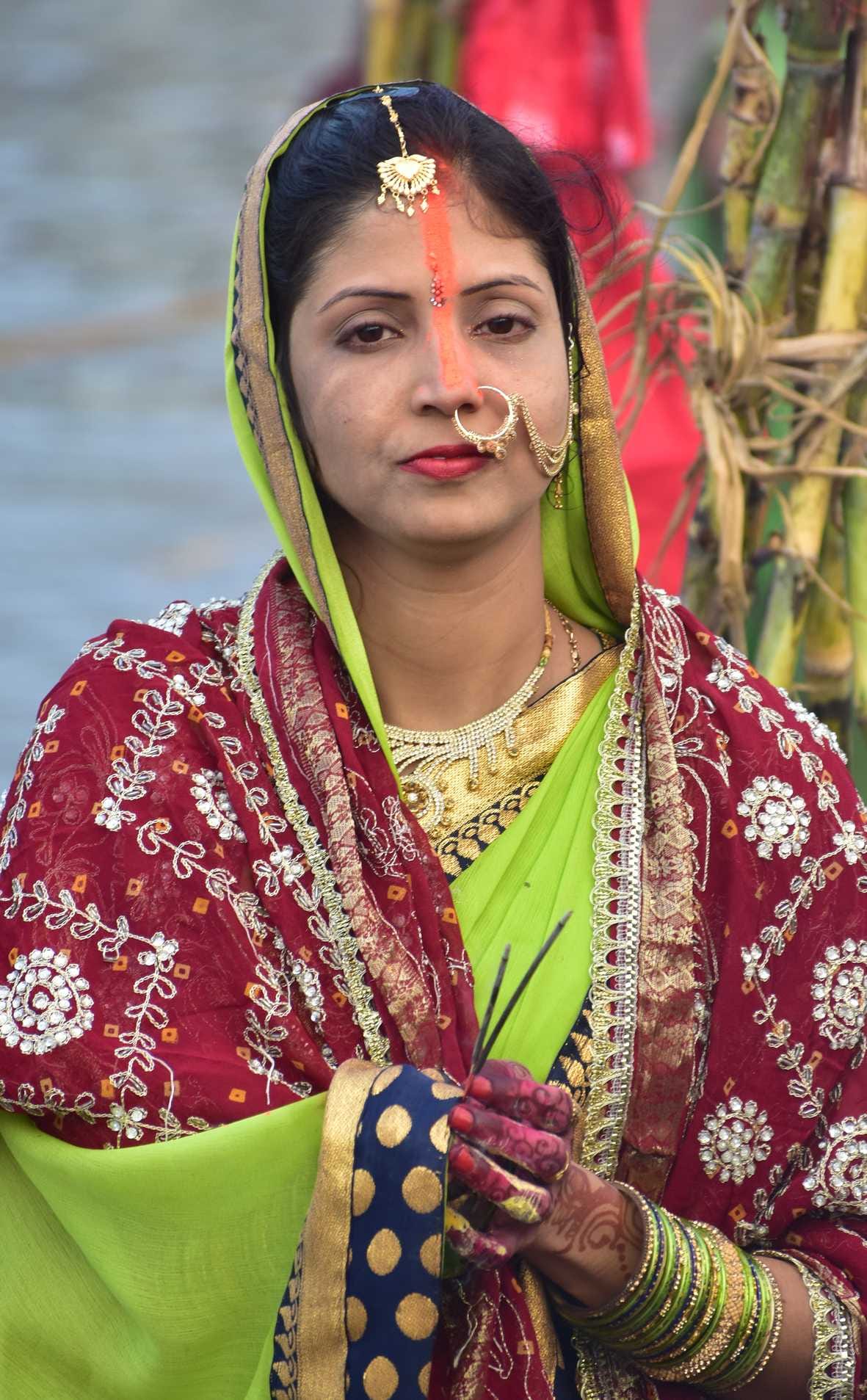 विसर्जन घाट पर नदी में खड़े होकर अस्ताचलगामी सूर्य के डूबने का इंतजार करती व्रती महिला विसर्जन घाट पर नदी में खड़े होकर अस्ताचलगामी सूर्य के डूबने का इंतजार करती व्रती महिला