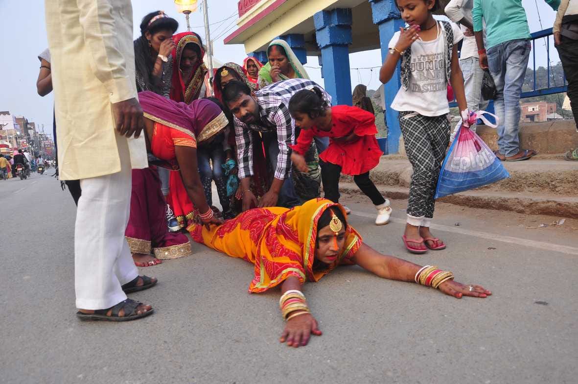 शाही पुल पर साष्टांग करते हुए गोमती नदी के घाट पर जाती व्रती महिला। शाही पुल पर साष्टांग करते हुए गोमती नदी के घाट पर जाती व्रती महिला।