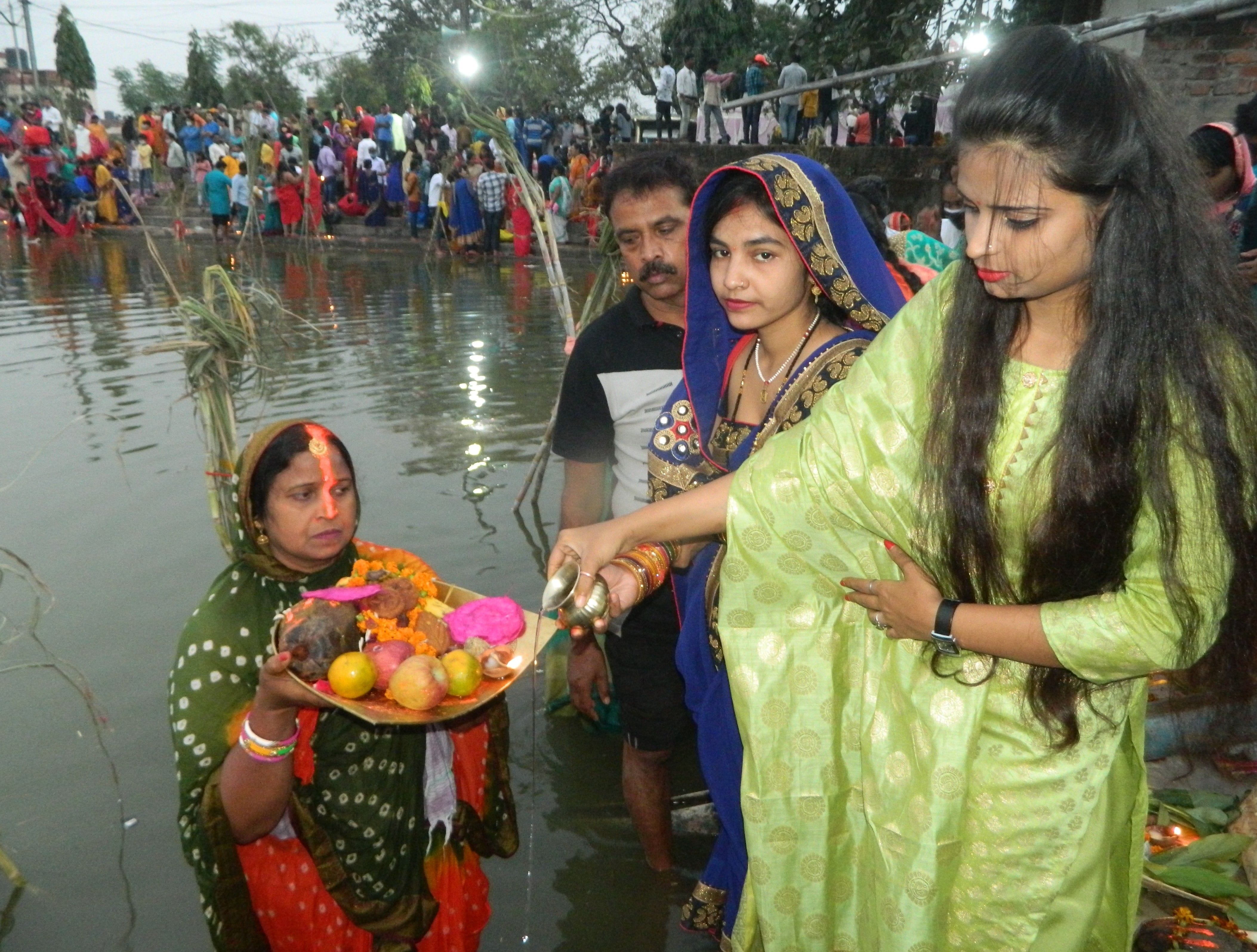 पीडीडीयू नगर स्थित तालाब पर व्रती महिला को अर्घ्य दिलातीं युवतियां। पीडीडीयू नगर स्थित तालाब पर व्रती महिला को अर्घ्य दिलातीं युवतियां।