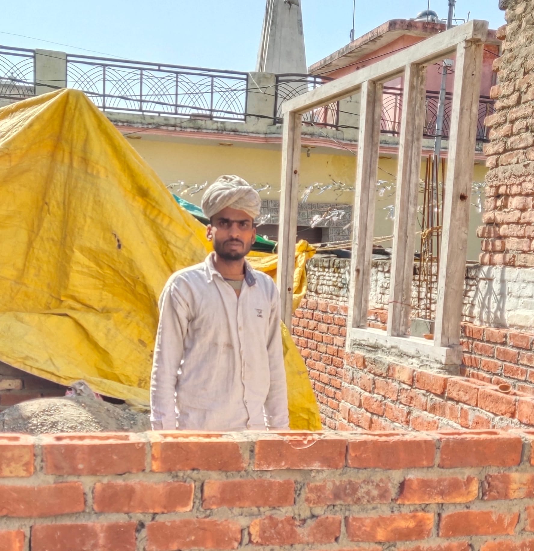 जलालाबाद में निर्माणाधीन मकान में खड़ा लाभार्थी अमित सैनी।