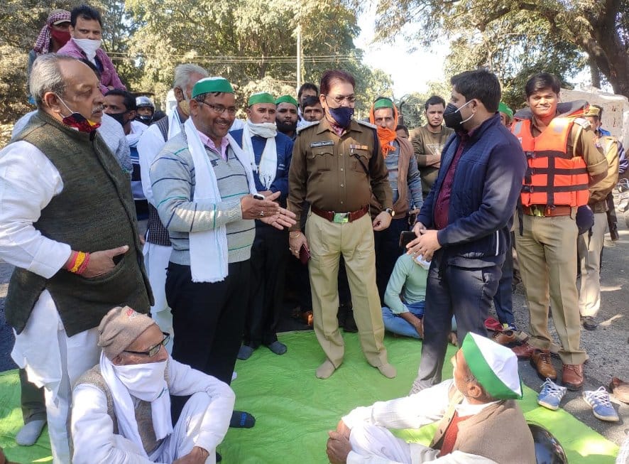 नजीबाबाद के मोटा महादेव मंदिर क्षेत्र में प्रदर्शनकारी किसानों से  वार्ता करते एसडीएम और सीओ।