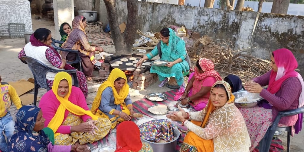नगीना में गुरुद्वारे में लंगर के लिए रोटी बनाती महिलाएं।
