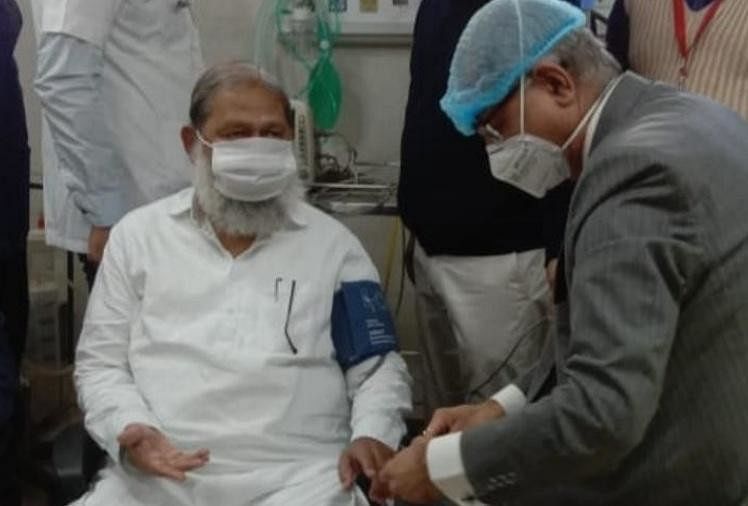 Doctors examine the Health Minister before applying the vaccine.