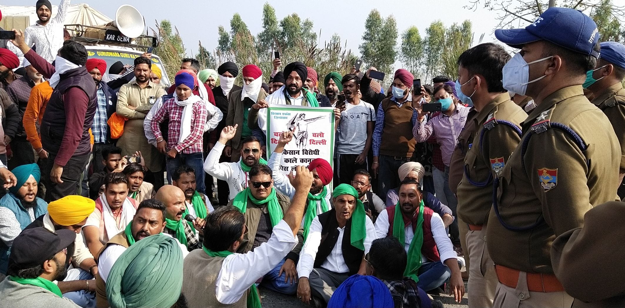 सितारगंज में किच्छा हाइवे पर पुलिस द्वारा रोकने के बाद धरना प्रदर्शन करते किसान।