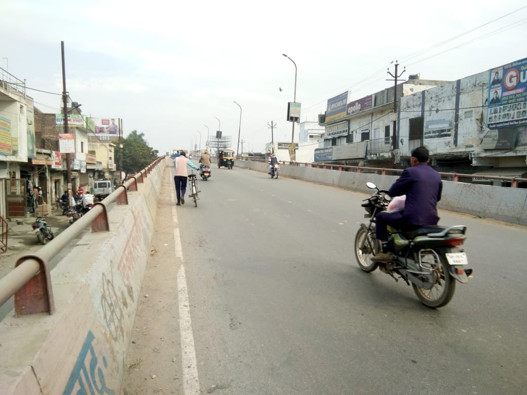 नजीबाबाद में फ्लाइओवर से गुजरते लोग।