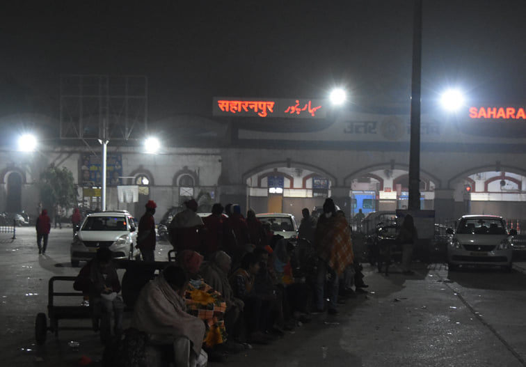 सहारनपुर में कोहरे और ठंड के चलते स्टेशन परिसर में बैठे लोग सहारनपुर में कोहरे और ठंड के चलते स्टेशन परिसर में बैठे लोग