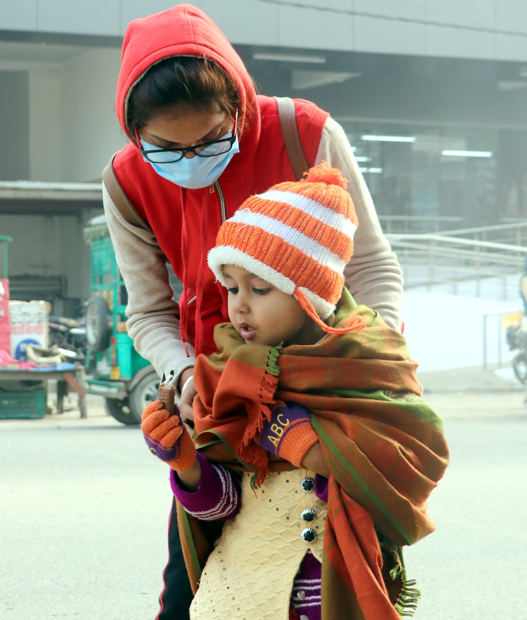 बिजनौर में कड़ाके की ठंड से बच्चे को बचाती युवती। बिजनौर में कड़ाके की ठंड से बच्चे को बचाती युवती।