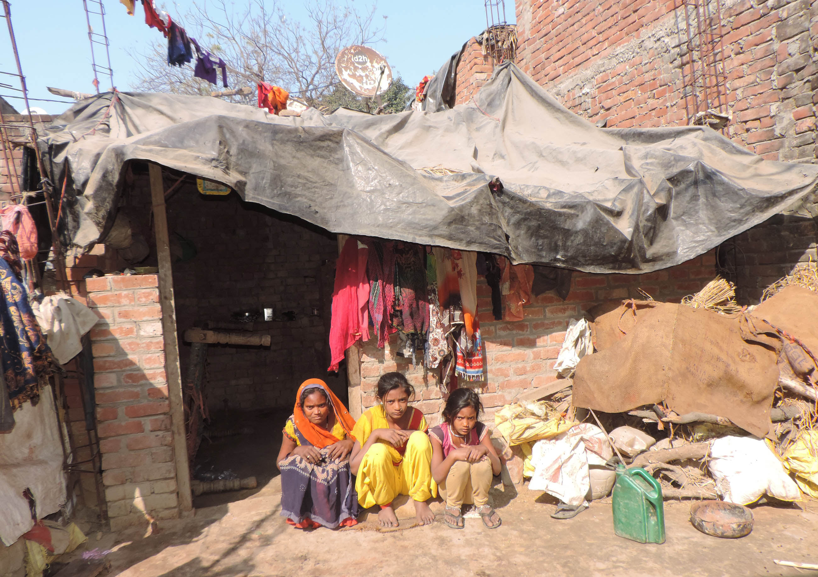 अधूरे प्रधान मंत्री आवास में पॉलीथिन डाल कर बच्चों के साथ बैठी सलमा। संवाद