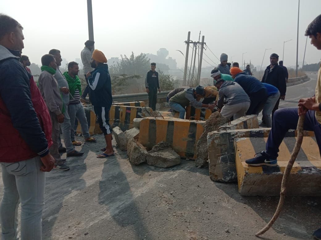 केजीपी से दिल्ली की तरफ उतरने वाले मार्ग पर बैरिकेड रखकर बंद करते किसान। संवाद केजीपी से दिल्ली की तरफ उतरने वाले मार्ग पर बैरिकेड रखकर बंद करते किसान। संवाद
