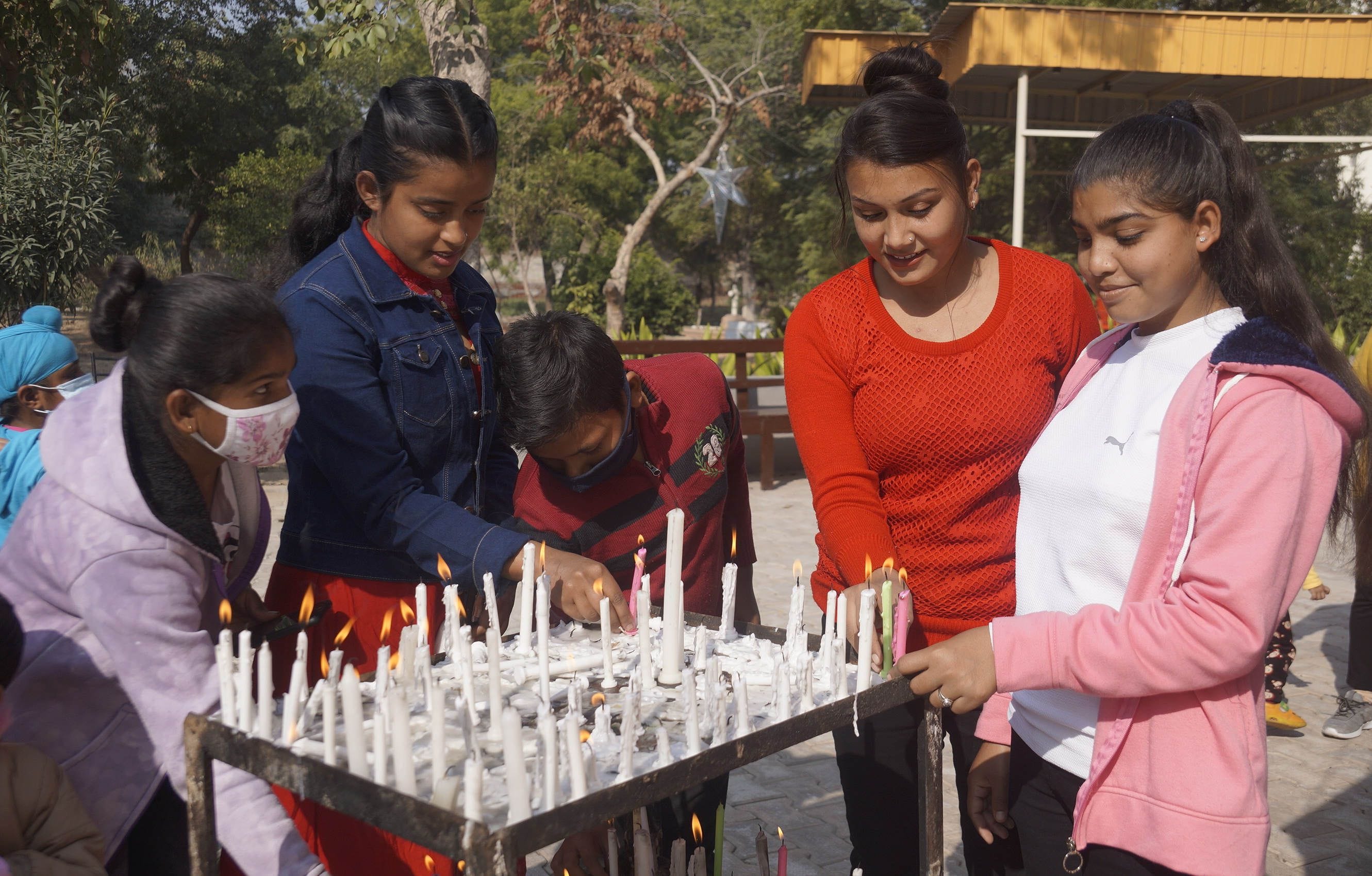 चर्च परिसर में कैंडल जलातीं युवतियां। चर्च परिसर में कैंडल जलातीं युवतियां।