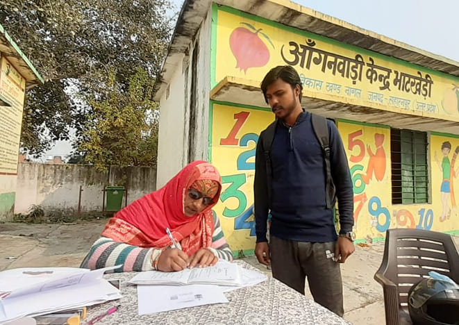 - भाटखेडी गांव के मतदान केंद्र पर बीएलओ से मतदाता सूची देखते मतदाता। - भाटखेडी गांव के मतदान केंद्र पर बीएलओ से मतदाता सूची देखते मतदाता।