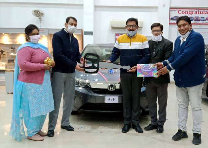 शहर के एक शोरूम से खरीदी गई कार की चाबी लेता परिवार। शहर के एक शोरूम से खरीदी गई कार की चाबी लेता परिवार।