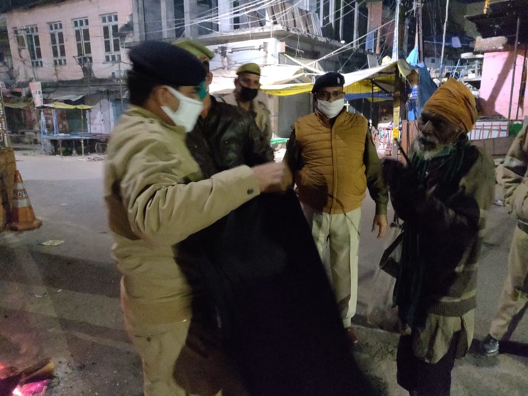 सड़क किनारे सो रहे लोगों को उठाकर कंबल वितरण करते पुलिस अधीक्षक प्रमोद कुमार