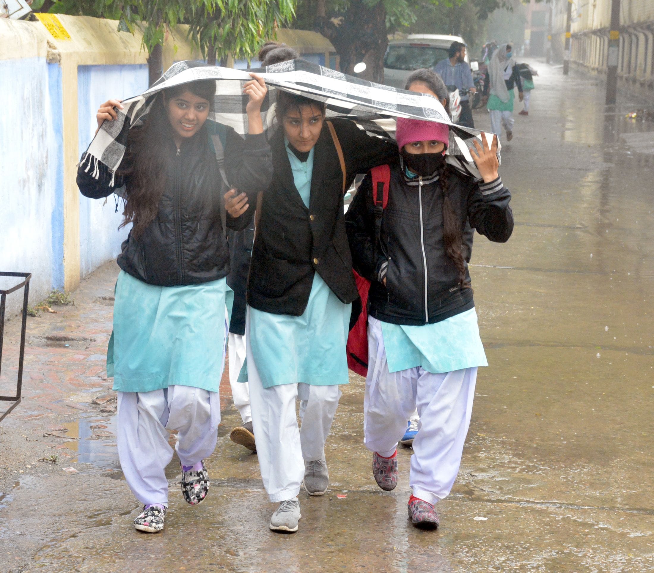 रामघाट रोड टीकाराम कन्या कॉलेज के गेट पर बारिश से बचने के लिए दुपट्टे का सहारा लेती युवतियां। रामघाट रोड टीकाराम कन्या कॉलेज के गेट पर बारिश से बचने के लिए दुपट्टे का सहारा लेती युवतियां।