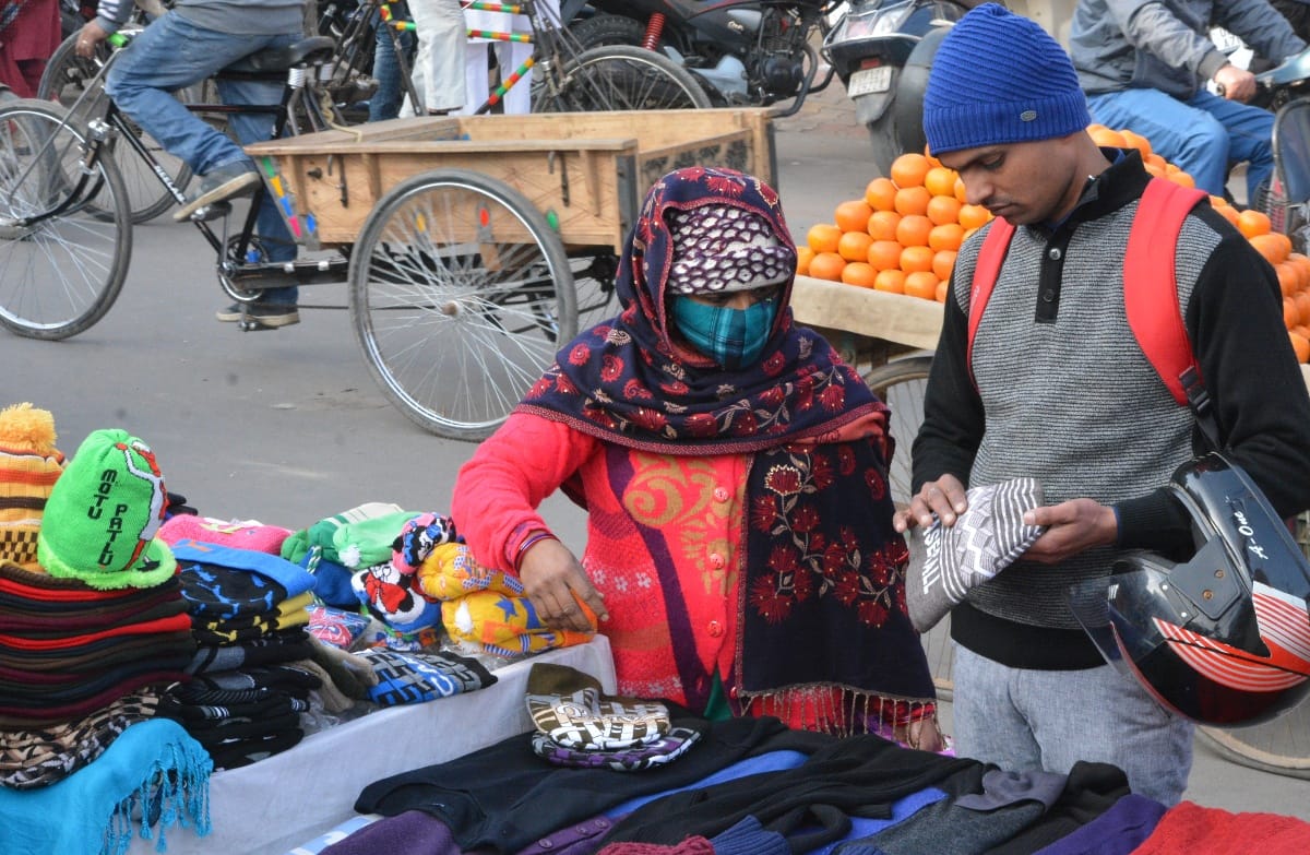 सर्दी में ऊनी टोपी की खरीददारी करते लोग। सर्दी में ऊनी टोपी की खरीददारी करते लोग।