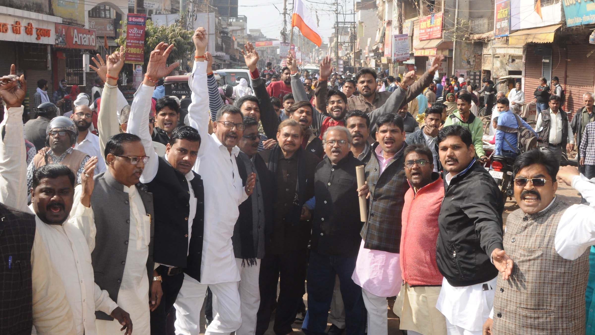 दुकानें बंद कर शहर में जुलूस निकाल कर प्रदर्शन करते व्यापार मंडल के लोग।