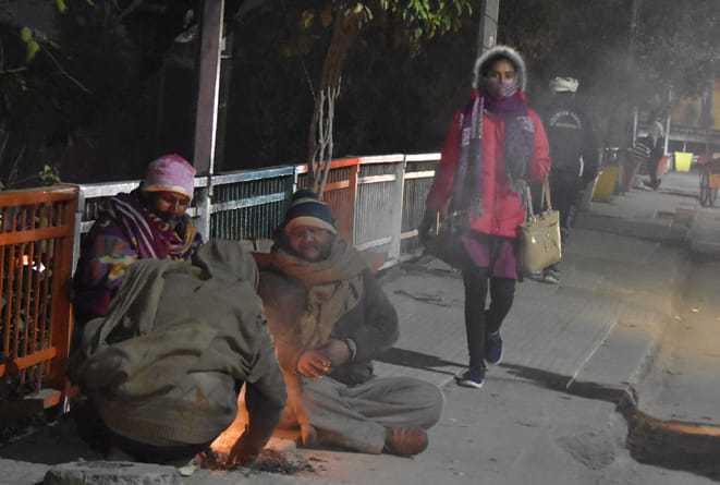 कोर्ट रोड़ पुल पर अलाव के सहारे बैठे लोग