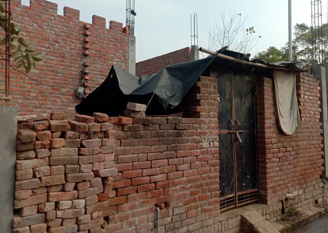 बिशनपुर में अधूरे मकान के सामने डाली गई तिरपाल।