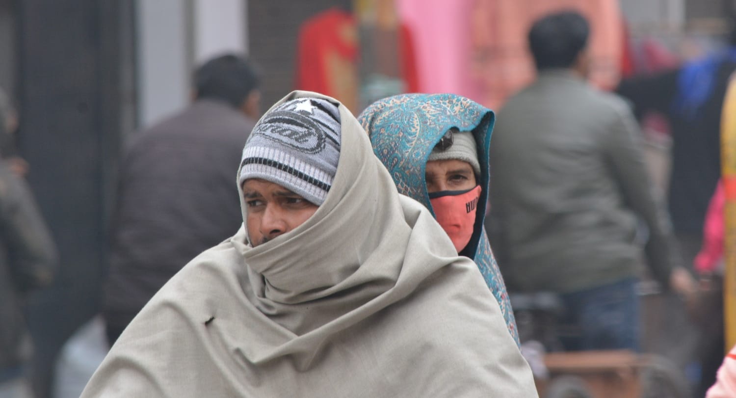 ठंड से बचाव के लिए ऊनी कंबल में जाते स्कूटी सवार। ठंड से बचाव के लिए ऊनी कंबल में जाते स्कूटी सवार।