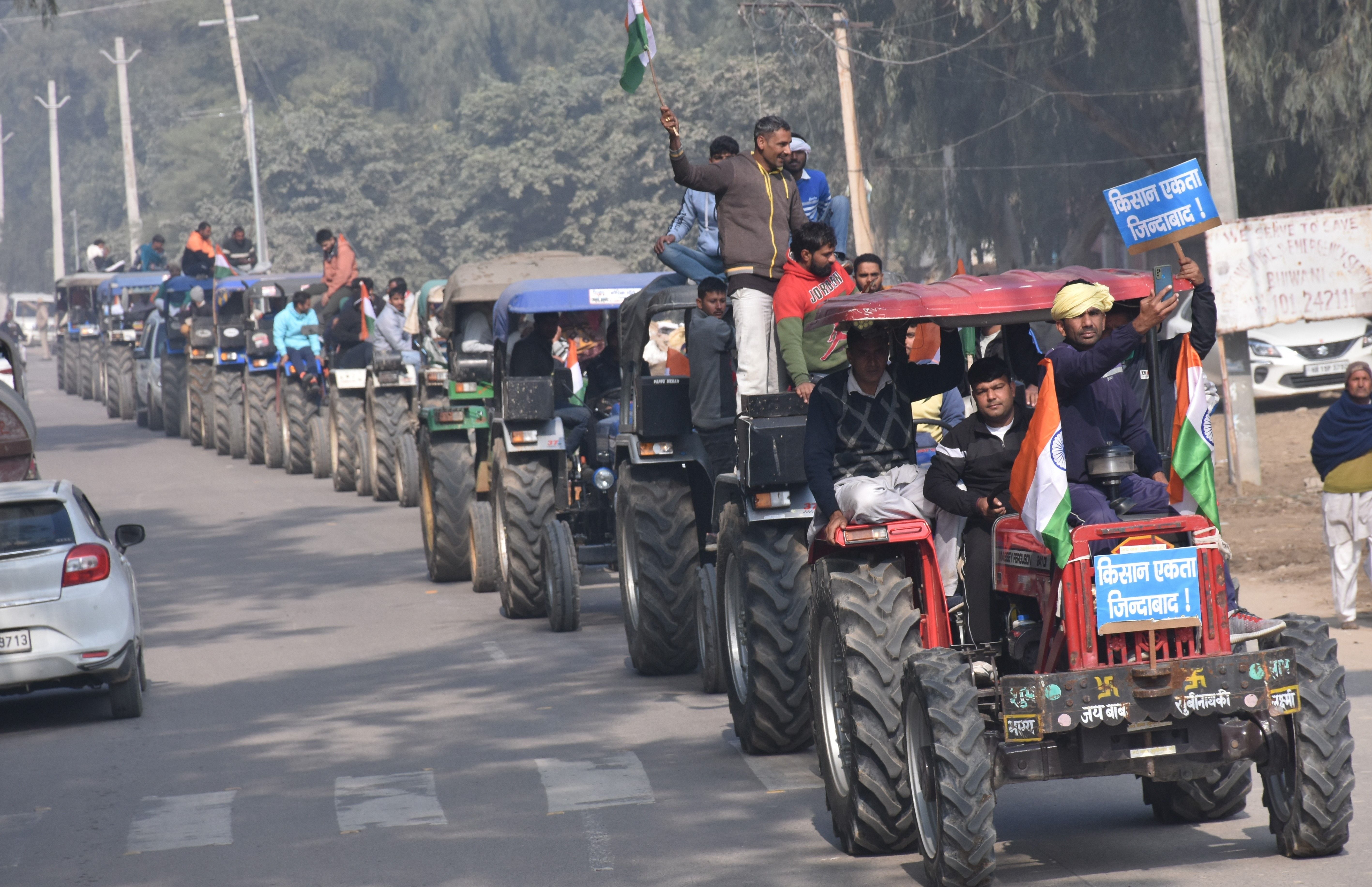  शहर में ट्रैक्टर रैली निकालते किसान। संवाद