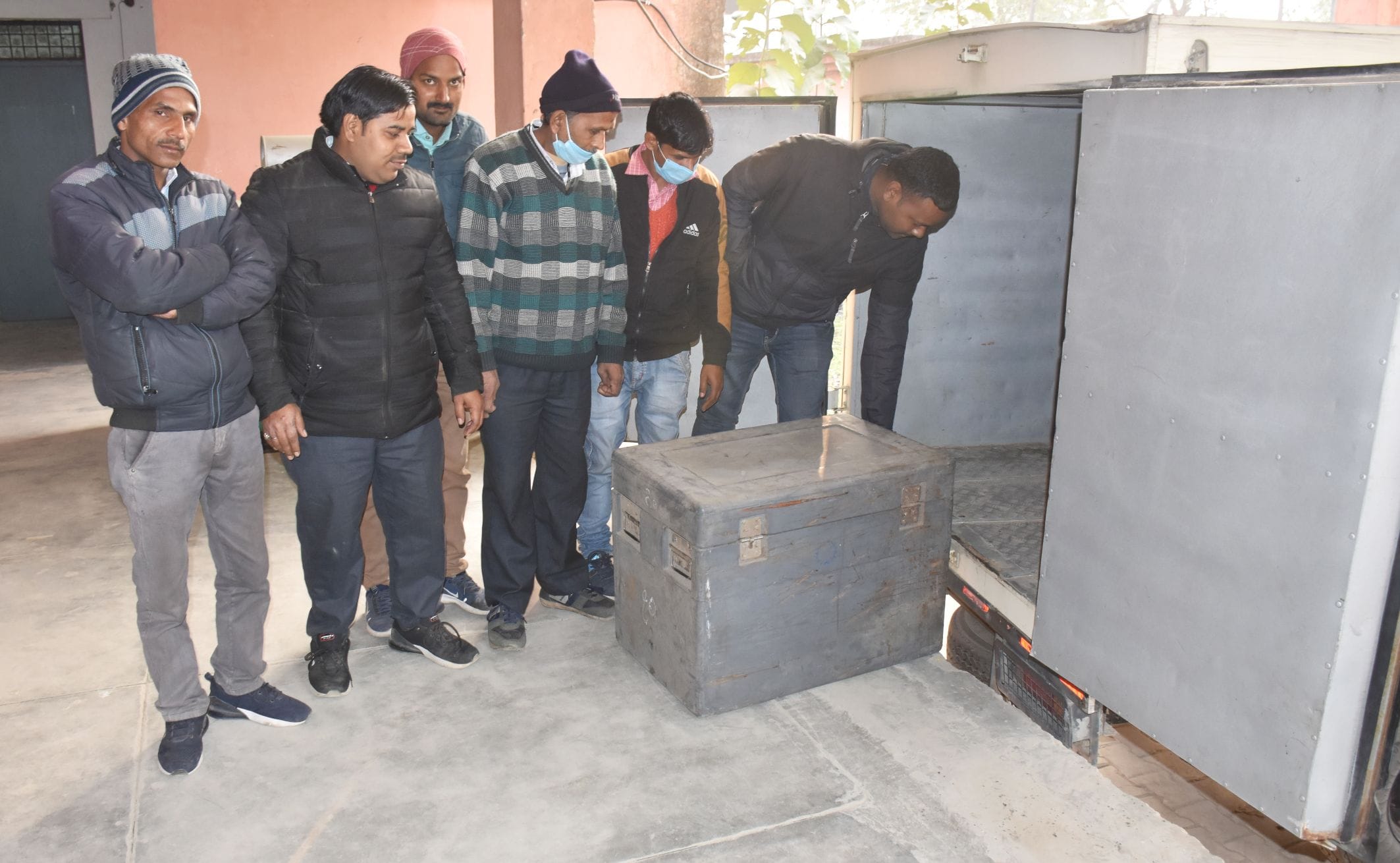 अयोध्या-मंडल मुख्यालय पर स्थित ड्रग वेयर हाऊस से कोरोना वैक्सीन के वितरण के दौरान मौजूद कर्मी