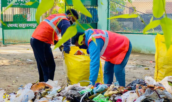 एमआरएफ सैंटर पर कचरा अलग करते कर्मी एमआरएफ सैंटर पर कचरा अलग करते कर्मी