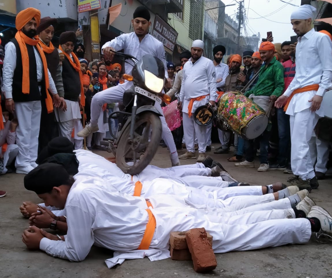 प्रभातफेरी में करतब दिखाते सिख समुदाय के युवा। प्रभातफेरी में करतब दिखाते सिख समुदाय के युवा।