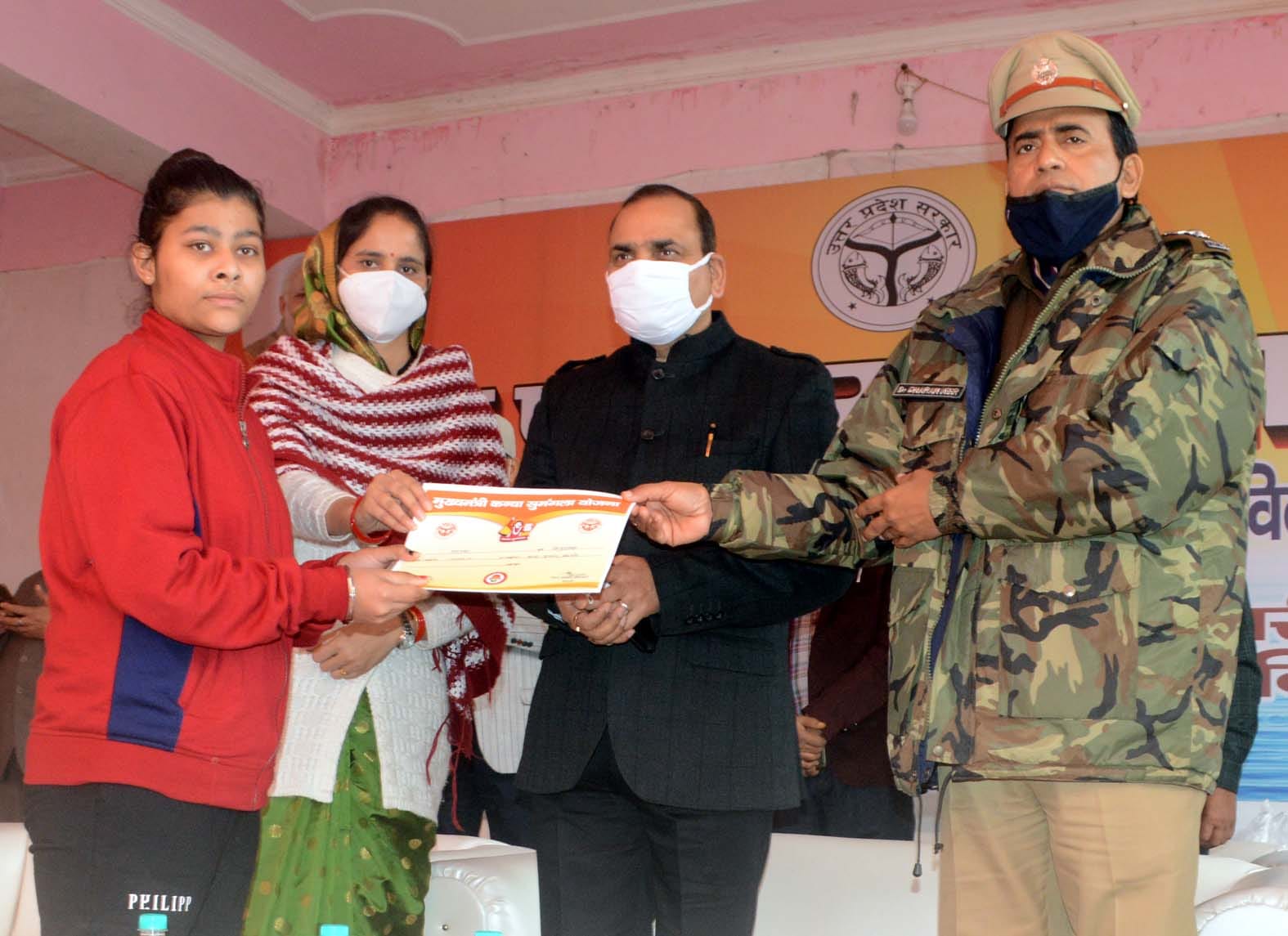 बिजनौर में इंदिरा बाल भवन में युवती को सम्मानित करते डीएम व विधायक।