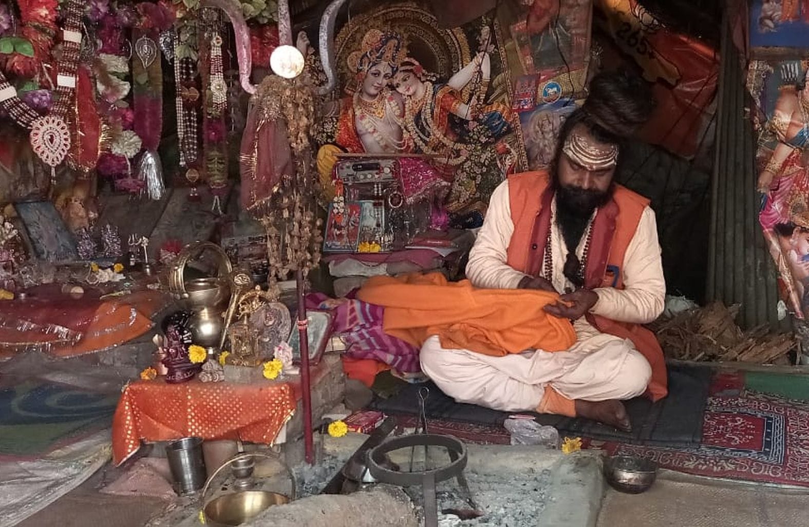 मेला रामनगरिया में सुई-धागा से कपड़ा सिलता साधु। संवाद