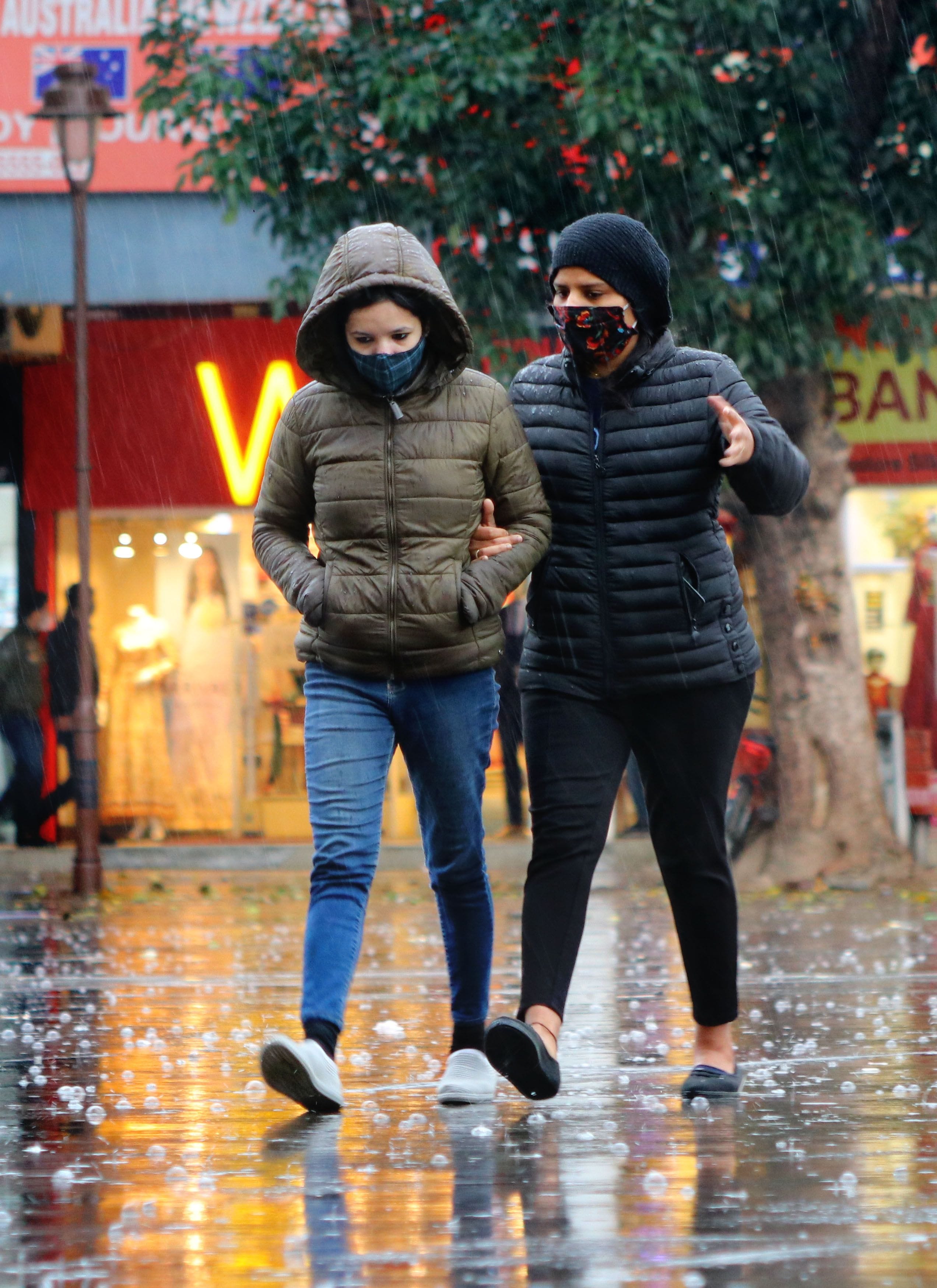 सेक्टर-17 में बारिश के दौरान गुजरतीं युवतियां।