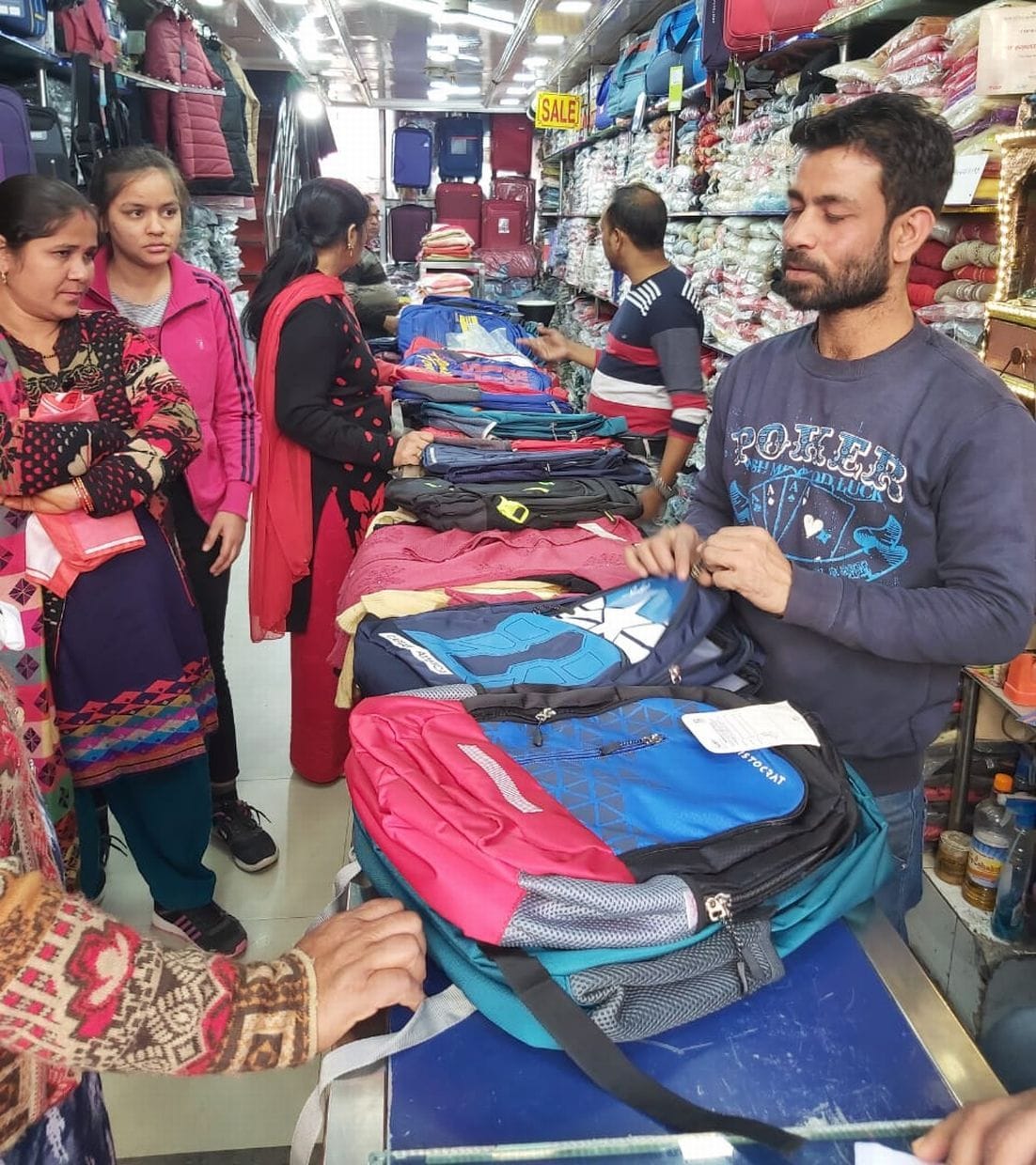 काशीपुर बाजार में बच्चों के स्कूल बैग खरीदते अभिभावक। काशीपुर बाजार में बच्चों के स्कूल बैग खरीदते अभिभावक।