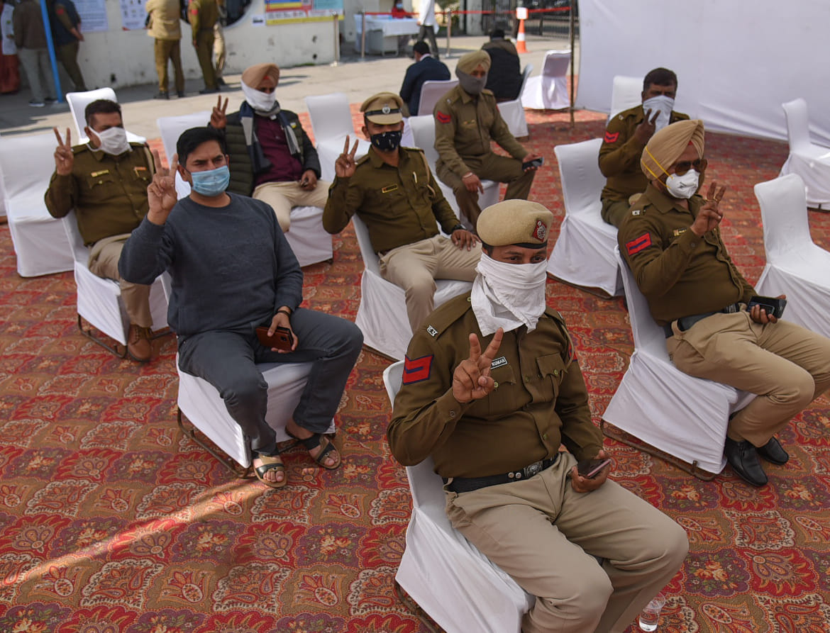 सेक्टर-16 की डिस्पेंसरी में वैक्सीन लगवाने के बाद विक्ट्री साइन दिखाते पुलिसकर्मी।