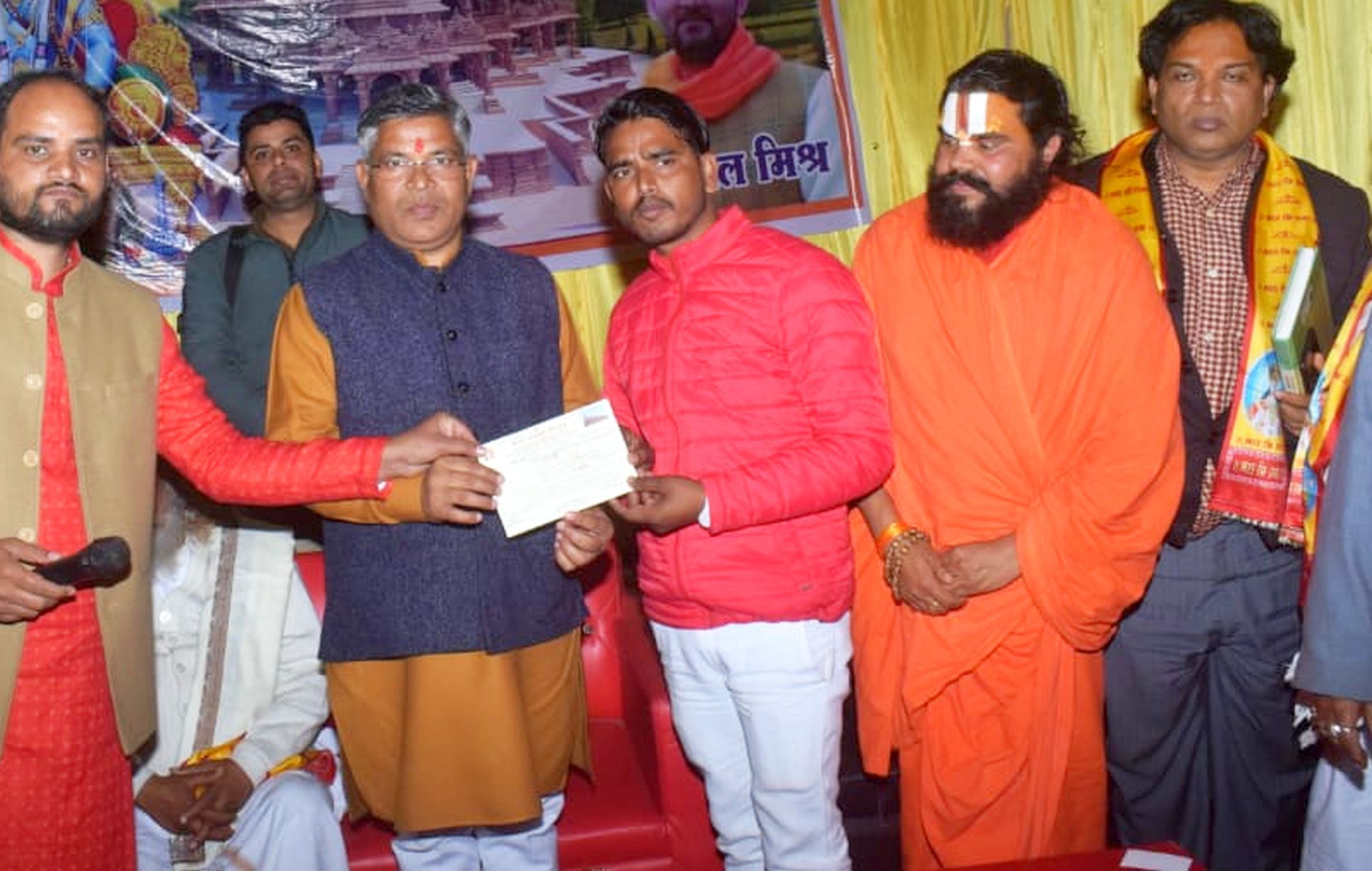 अयोध्या-राजेंद्र निवास पर आयोजित  निधि समर्पण कार्यक्रम में चेक सौंपते भक्त