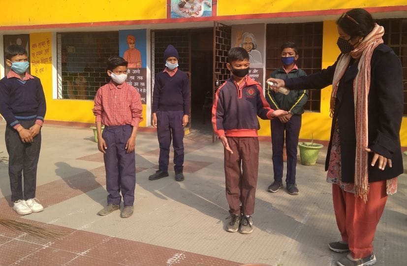 रुद्रपुर बीआरसी स्थित उच्च प्राथमिक स्कूल में बच्चों को सैनिटाइजर लगाती प्रधानाध्यापक।