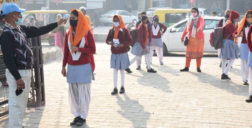 ुद्रपुर के श्रीगुरुनानक बालिका इंटर कॉलेज में छात्राओं की थर्मल स्क्रीनिंग करता कर्मचारी।