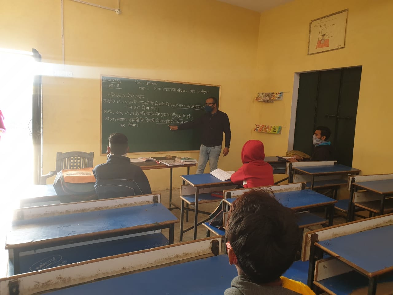 शाहपुर में जूनियर हाईस्कूल गोकुलपुर में विद्यार्थीयों  पढाता शिक्षक।