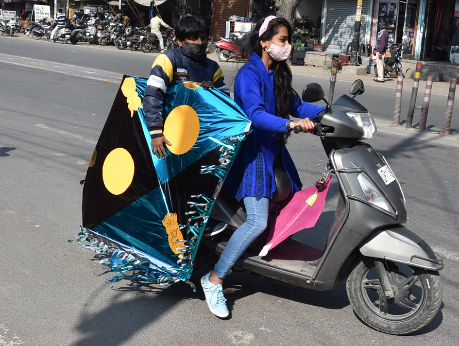 देहरादून रोड़ पर बसंत पंचमी के लिये स्कूटी पर पतंग लेजाती युवती देहरादून रोड़ पर बसंत पंचमी के लिये स्कूटी पर पतंग लेजाती युवती