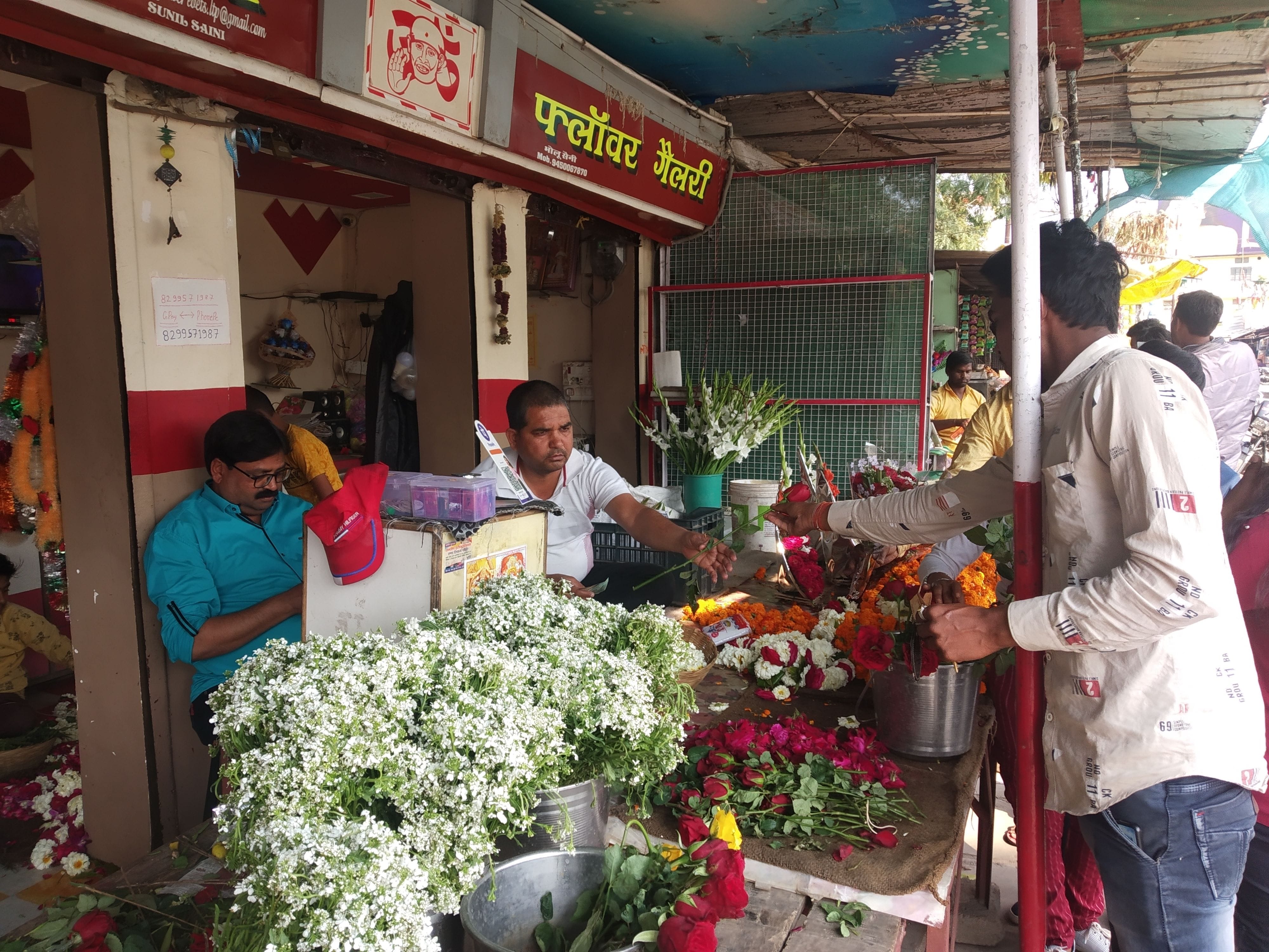 वेलेंटाइन डे पर चेहरा छिपाकर फूल खरीदते युवा