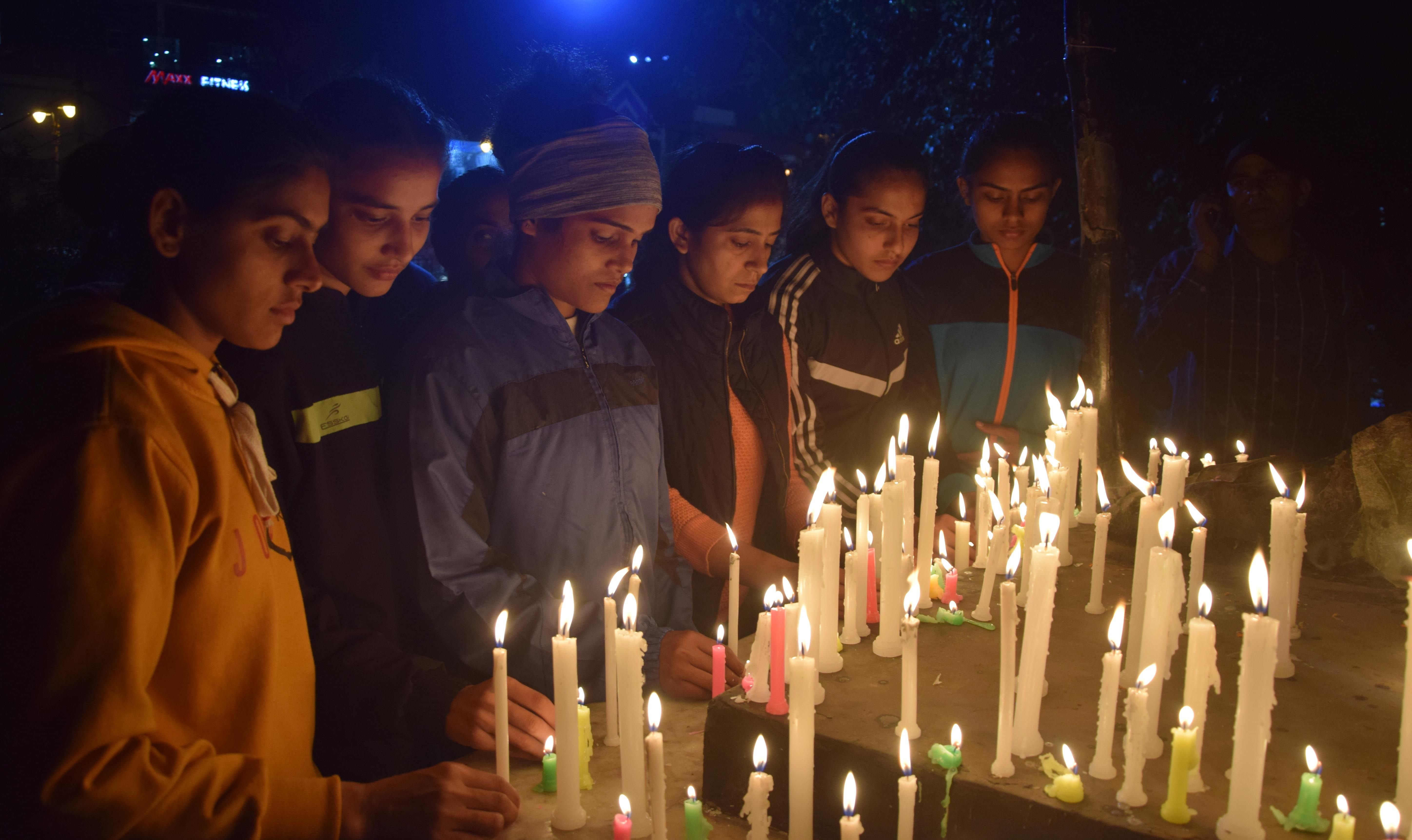 डी पार्क स्थित गांधी प्रतिमा पर कैंडल जलातीं महिला पहलवान। अमर उजाला