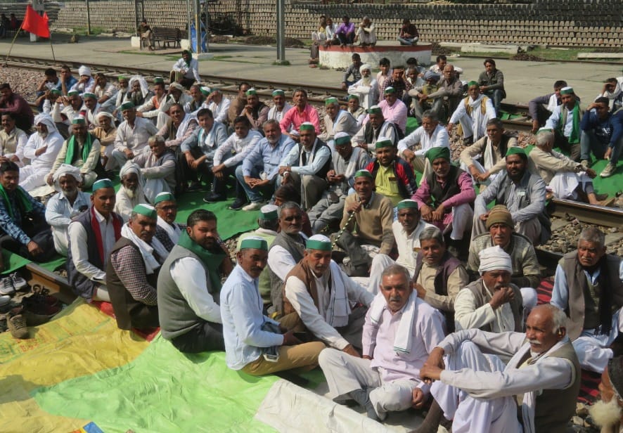 नजीबाबाद के मौअज्जमपुर नारायण रेलवे जंक्शन पर रेल ट्रेक पर बैठे किसान।