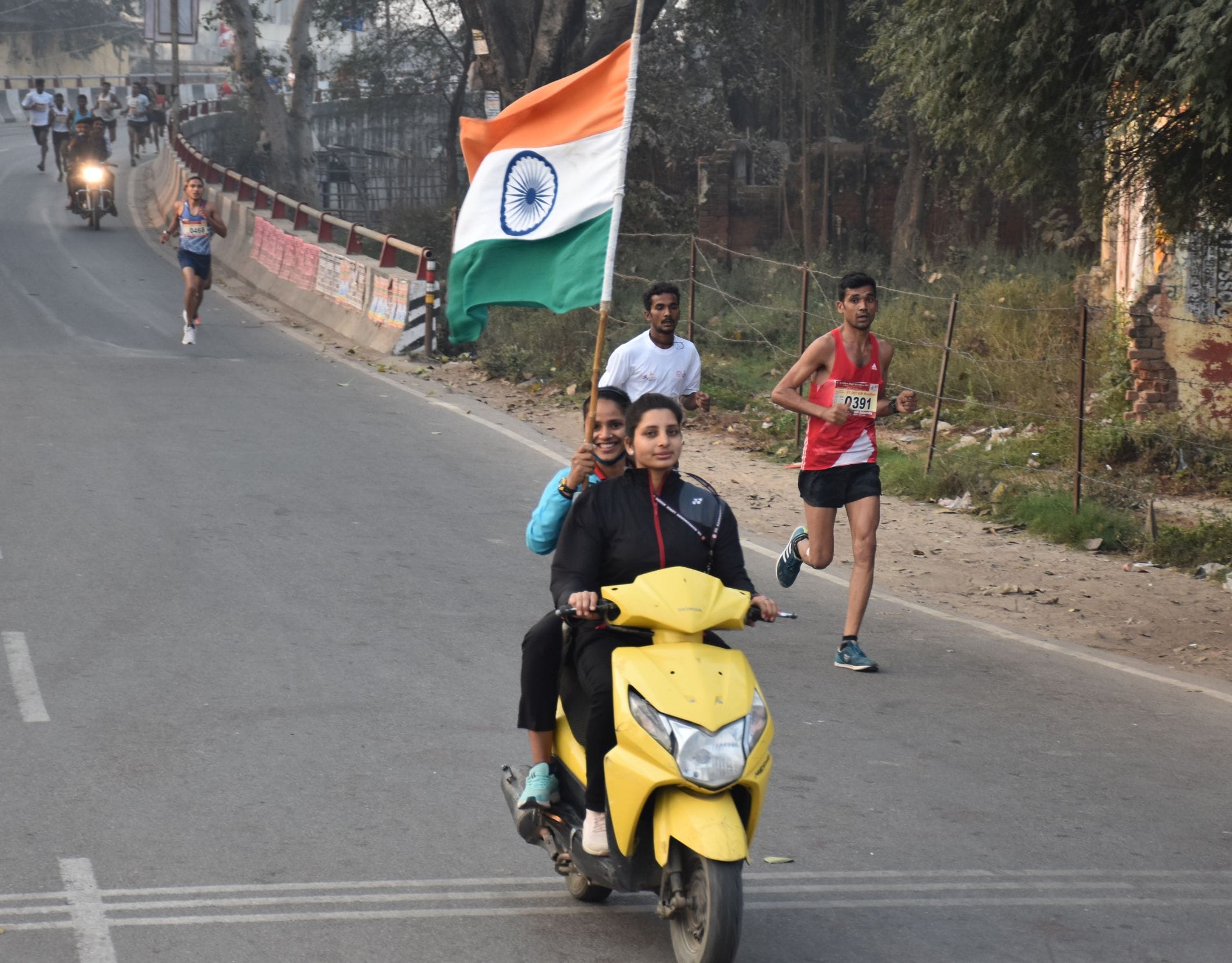 17-अवध विश्वविद्यालय से निकली हॉफ मैराथन प्रतियोगिता के दौरान तिरंगा लेकर स्कूटी से आगे चलतीं युव