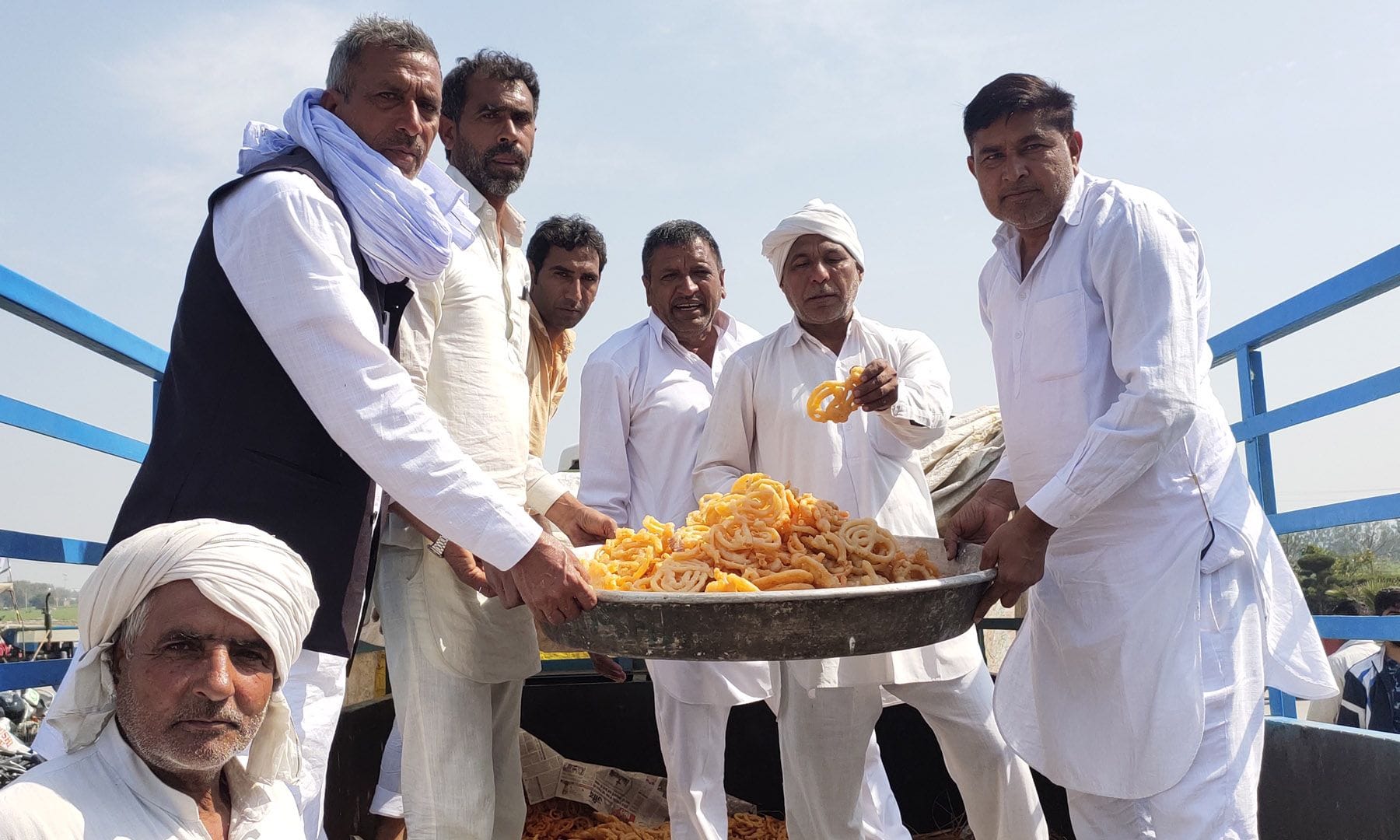 धरने में जलेबी बांटते हमीरगढ़ के किसान। संवाद। धरने में जलेबी बांटते हमीरगढ़ के किसान। संवाद।
