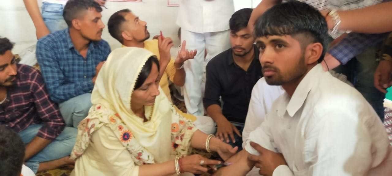 युवा के हाथ से खून निकालती महिला। 