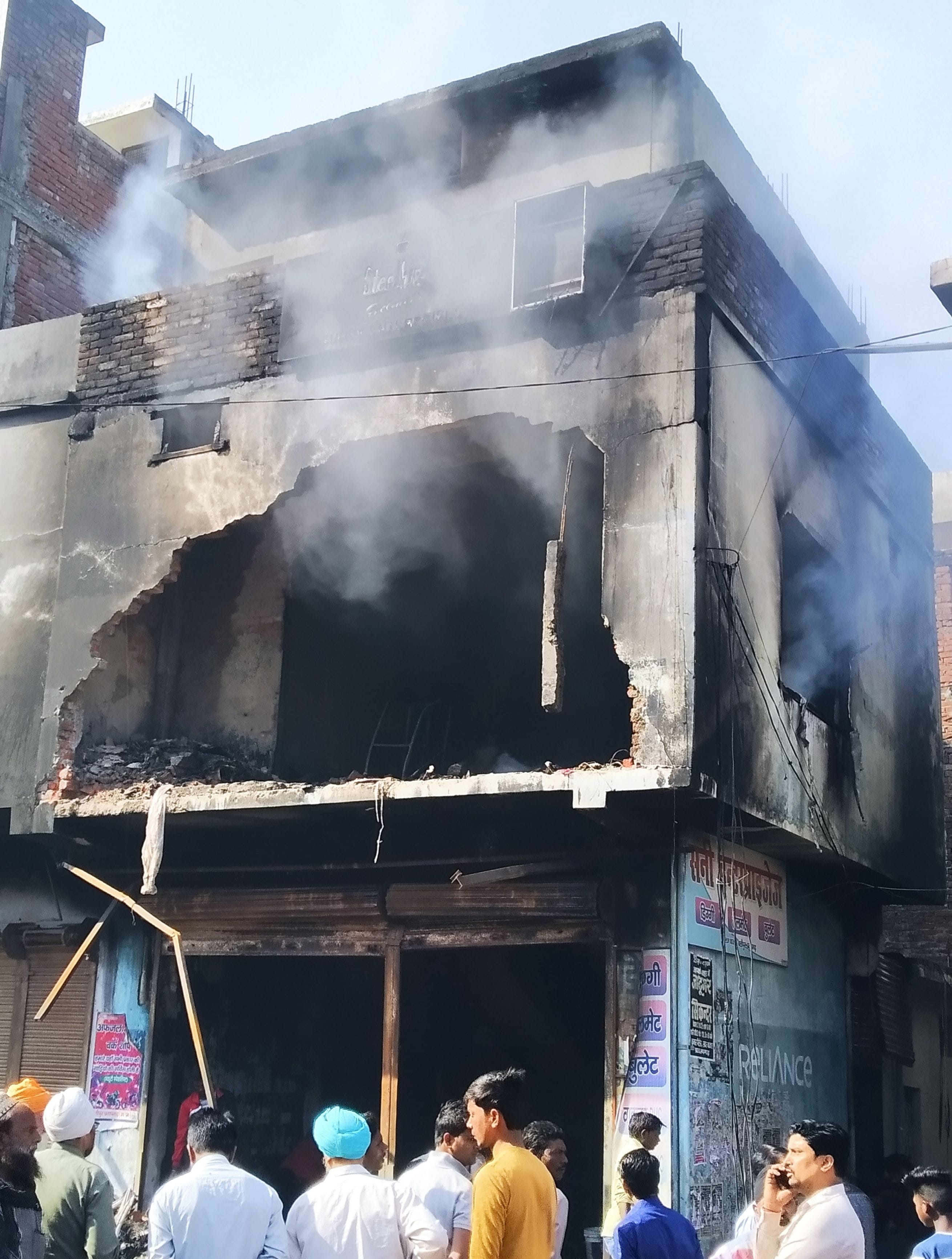 नगर कोतवाली के बलीपुर में आटो पार्ट्स की दुकान में रात में लगी आग का सुबह तक उठता धुंआ।