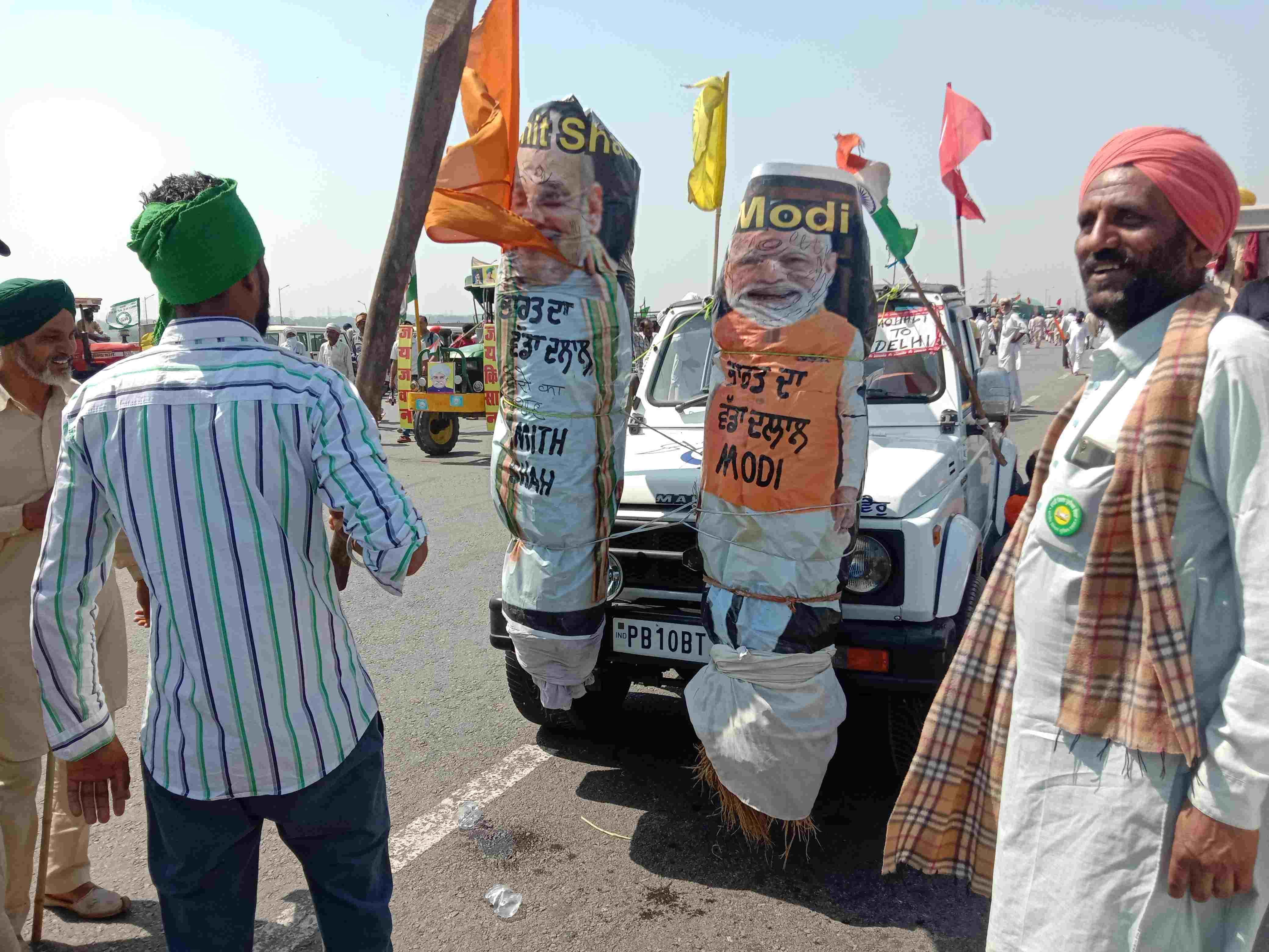 केएमपी पर जाम के दौरान केंद्र सरकार के पुतले गाड़ी पर बांधकर ले जाते किसान।