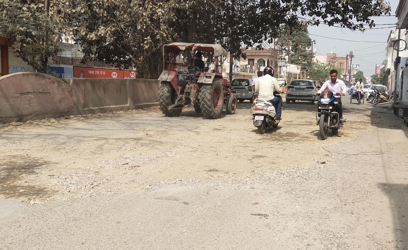नई मंडी की सेन रोड पर बने गढ्डों में से जाते वाहन सवार। नई मंडी की सेन रोड पर बने गढ्डों में से जाते वाहन सवार।